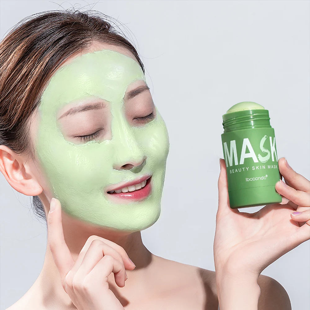 Woman with closed eyes applying green tea cleansing stick mask on her face, skincare product in a green stick format for deep cleansing and refreshment