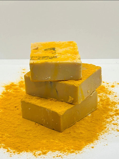 Turmeric soap bars with yellow powder on white background
